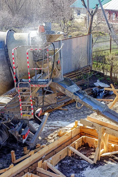 The machine prepares the concrete for casting. Spray of water over concrete mixing machine