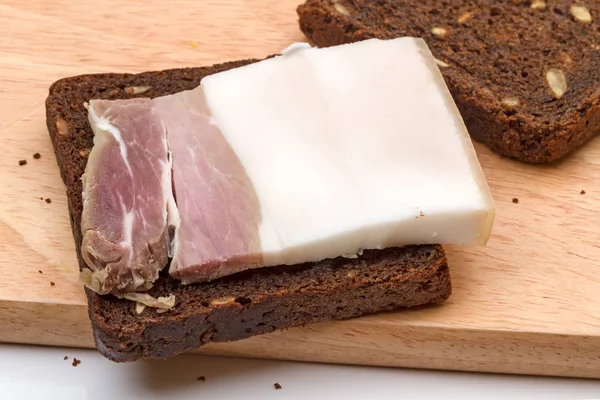 Pedaço de bacon salgado e pão de centeio — Fotografia de Stock