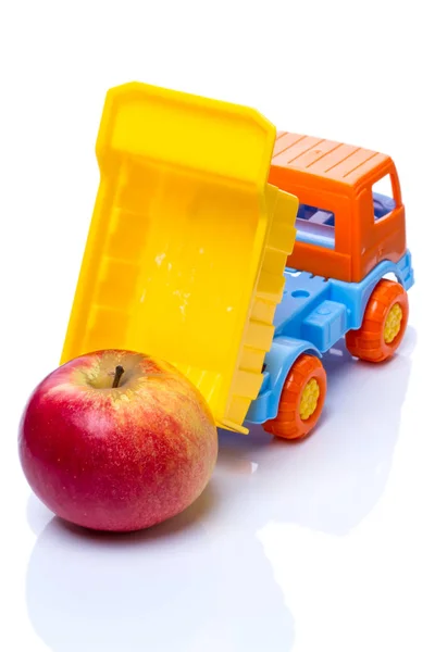Camión volquete de juguete y manzana —  Fotos de Stock