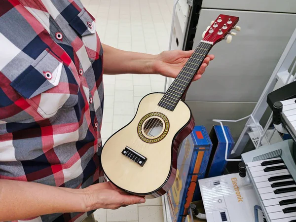 Kleine zes-snarige gitaar in de hand — Stockfoto