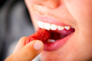 Kadın ısırık sosis füme. Sığ derinlik-in tarla.