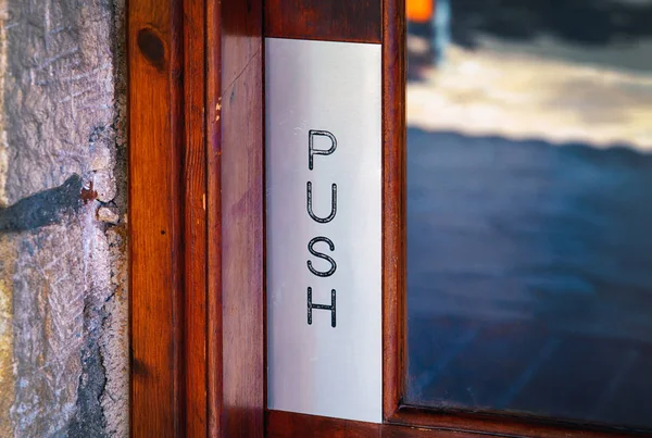 Wooden door with world Push. Closeup.
