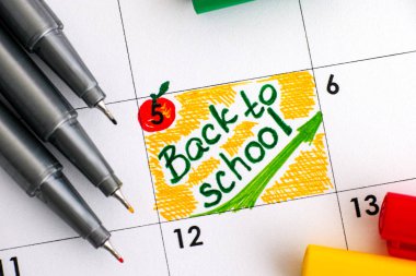 Okul takvim ile renkli kalemler için uyarı mektubu. Yakın çekim.