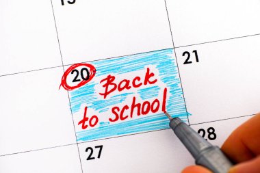 Kadın parmakları ile uyarı mektubu yazmaya kalem, Takvim içinde okula geri. Yakın çekim.