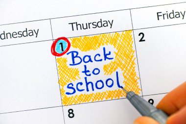 Kadın parmakları ile uyarı mektubu yazmaya kalem, Takvim içinde okula geri. 1 Eylül. yakın çekim.