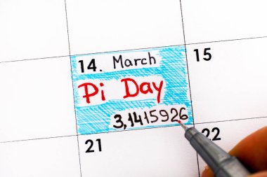 Kadın parmakları hatırlatma Pi günü Takvim içinde yazma kalemi ile. Pi Günü 14 Mart kutladı (3/14) dünya çapında.