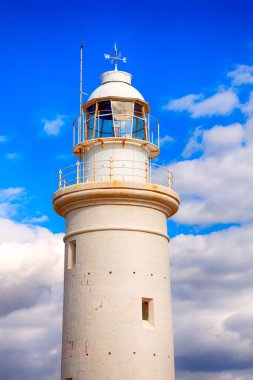 Mavi gökyüzü bulutlu karşı Paphos Kıbrıs'taki beyaz deniz feneri.