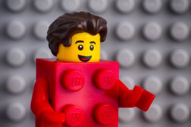 Tambov, Rusya Federasyonu - 29 Temmuz 2018 Lego kırmızı takım elbise tuğla adam minifigure gri baseplate bir arka plana dayanır. Stüdyo vurdu.