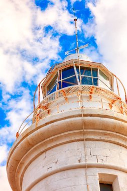 Mavi gökyüzü bulutlu beyaz feneri. Yakın çekim.