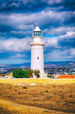 Paphos Archaeological Park Kıbrıs'taki beyaz feneri ile bulutlu gökyüzü.