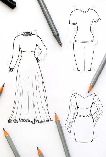 Hand drawing clothes for paper doll with black pen and pencils.