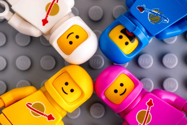 Vier Lego-Astronauten-Minifiguren auf grauem Untergrund. — Stockfoto