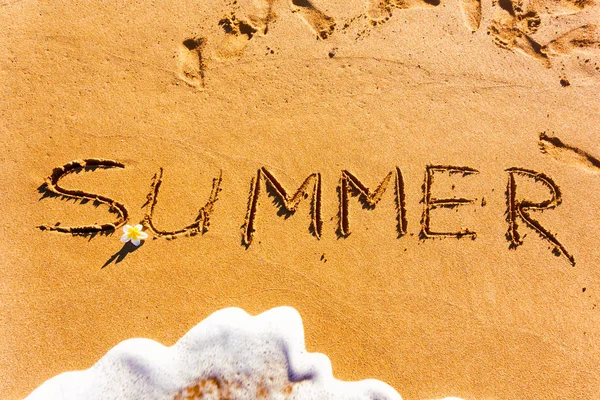 波と花が付いている砂に書かれた単語夏. — ストック写真