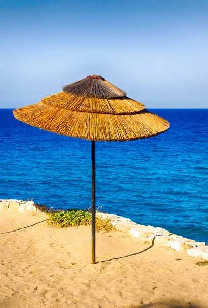 Sonnenschirm aus Stroh am Meeresstrand. — Stockfoto