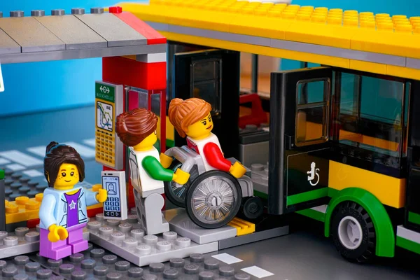 Lego-Bushaltestelle mit Bus und Fahrgast - Frau hilft Frau in — Stockfoto