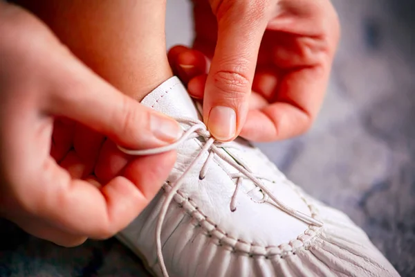 여자 손에 흰색 구두에 구두 끈을 묶는. — 스톡 사진