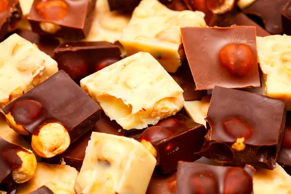 Pieces of white and dark chocolate with nuts. — Stock Photo, Image