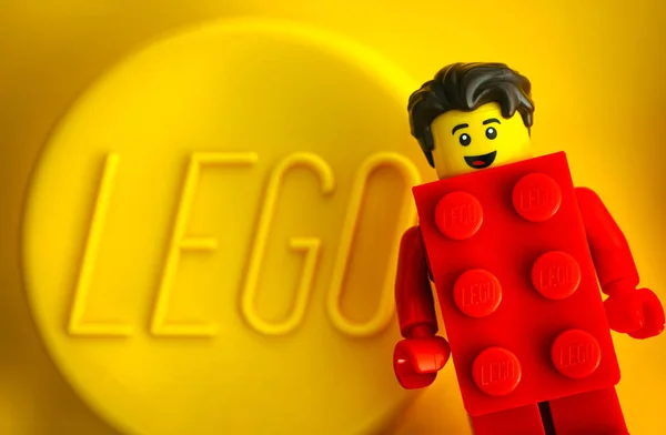 Lego Red Suit Brick Guy minifigura contra fundo amarelo sagacidade — Fotografia de Stock