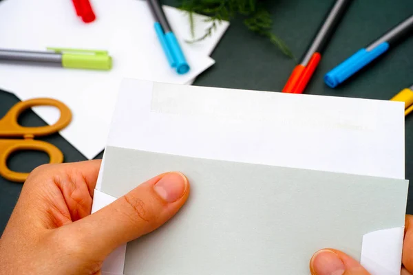 Nahaufnahme einer Frau, die einen Brief aus dem Umschlag nimmt. — Stockfoto