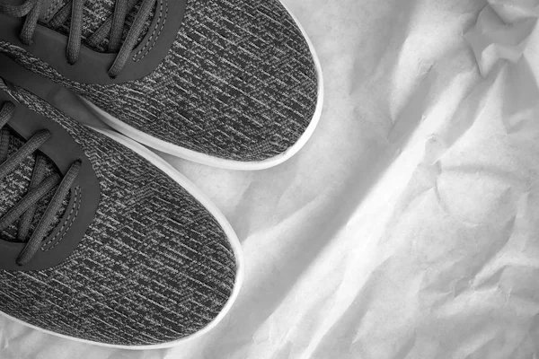 Šedé běžící boty na zmačkaném papíře — Stock fotografie