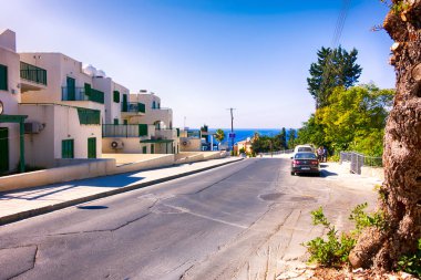 Beyaz binalar ile Chloraka Village sokak aşağı se gider