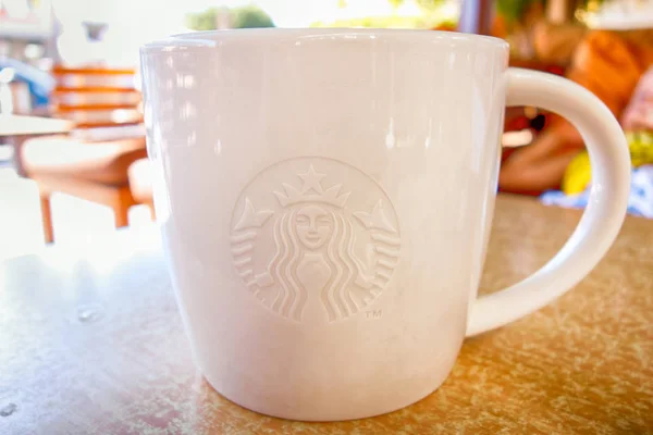 Close-up de caneca branca Starbucks na mesa ao ar livre . — Fotografia de Stock