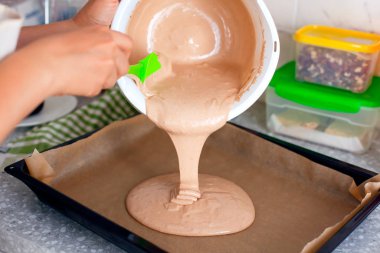 Kadın elleri hamuru pişirme tepsisine koyar