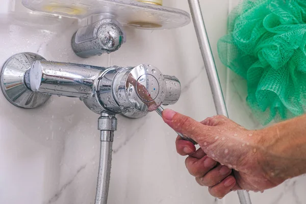 Persona mano usando grifo en ducha . — Foto de Stock