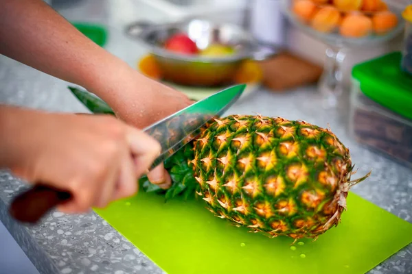 Женские руки с ножевым резанием ананаса — стоковое фото