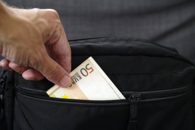 Siyah çantadan elli euro alan kişi el. Yakın çekim.