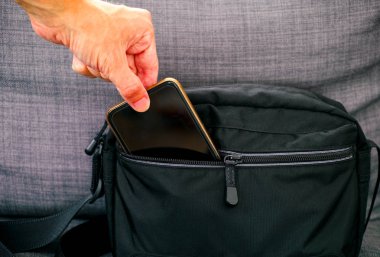 Adam el Siyah çanta cep telefonu alma. 