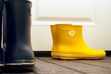 Kapının yakınındaki koridorda duran iki çift lastik bot.