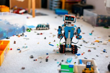 Lego Boost robot diğer Lego oyuncaklar ile odada duran, tuğla bir