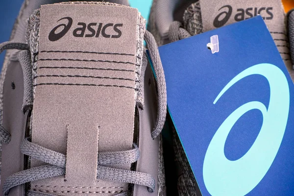 Close-up of new gray Asics running shoes with tag. — Stock Photo, Image