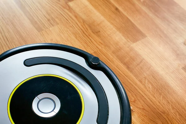 Robot de limpieza al vacío en el suelo de parquet . — Foto de Stock