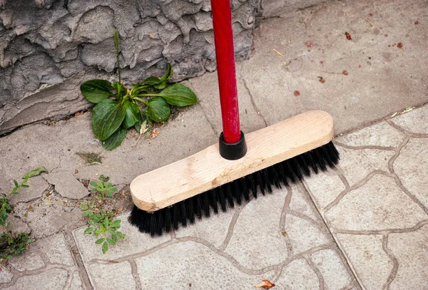 Besen steht neben Mauer draußen — Stockfoto