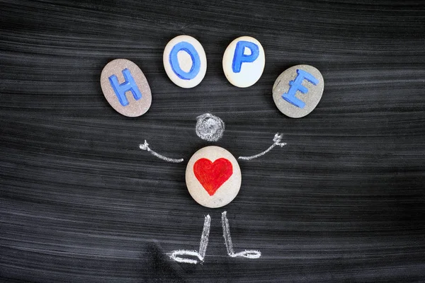 Pebble with red hearts inside chalk drawing of man and letters H — Stock Photo, Image