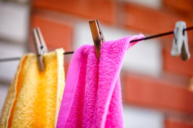 Dışarıda çamaşır ipinde asılı iki havlu ve mandallar.. 