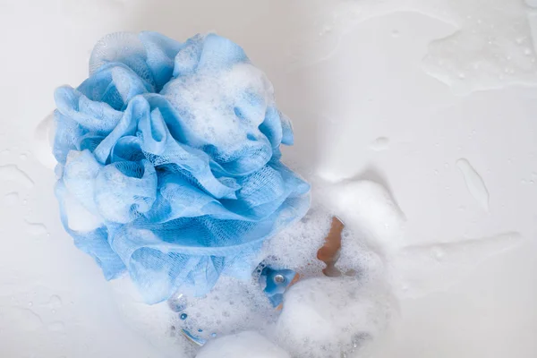 Esponja azul com espuma no chão do banho de chuveiro . — Fotografia de Stock