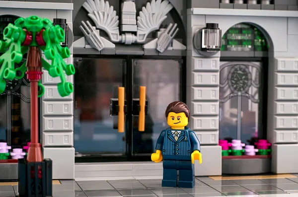 Lego businessman standing at the entrance to the Lego bank. — Stock Photo, Image