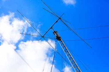 Bulutlu gökyüzüne karşı amatör radyo anteni.