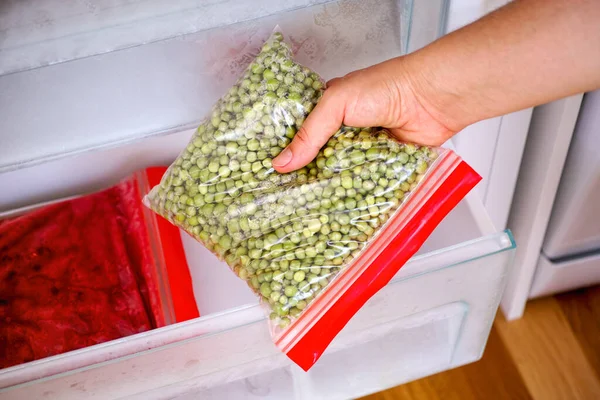 Женская Рука Вынимает Домашнюю Упаковку Зеленого Горошка Морозилку — стоковое фото