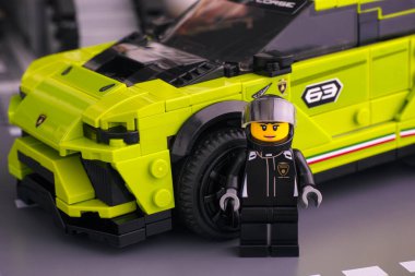 Tambov, Rusya Federasyonu - 24 Haziran 2020 Lego Lamborghini Urus ST-X sürücü minifiki arabasının yanında. LEGO Hız Şampiyonları.