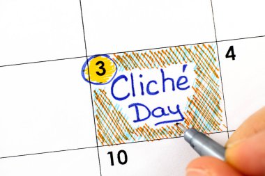 Woman fingers with pen writing reminder Cliche Day in calendar. November 3.  clipart