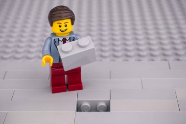 Tambov, Rusya Federasyonu - 07 Haziran 2020 Lego işadamı Gri tuğlalı bir boşluğu doldurmaya hazır
