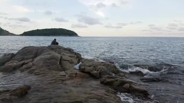 Mujer joven y niño pequeño establecidos en la roca — Vídeo de stock