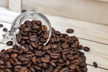 Fincan ve beyaz ahşap arka plan üzerinde kahve tahıl