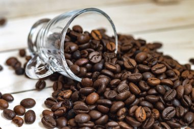 Fincan ve beyaz ahşap arka plan üzerinde kahve tahıl