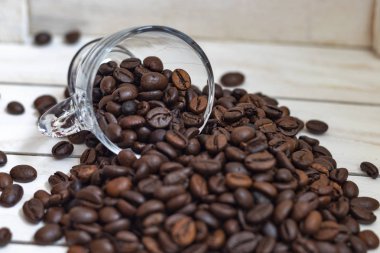 Fincan ve beyaz ahşap arka plan üzerinde kahve tahıl