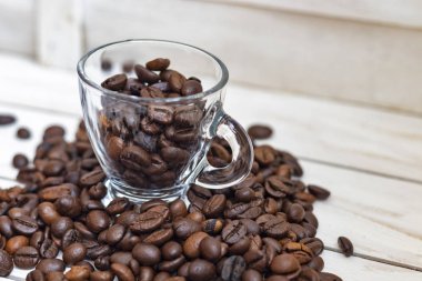 Fincan ve beyaz ahşap arka plan üzerinde kahve tahıl